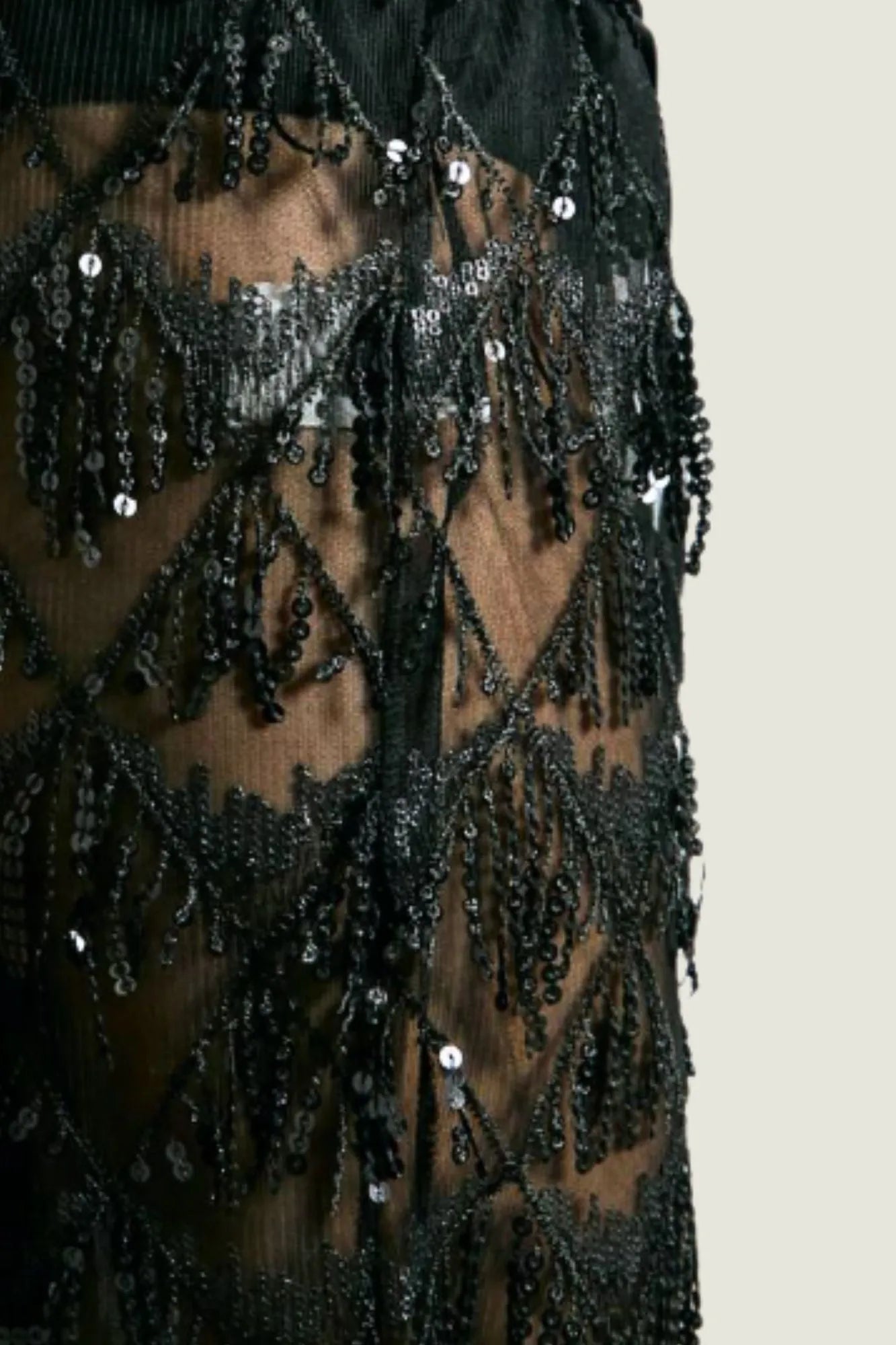 Modelo feminina usando calça preta transparente em tule bordado com lantejoulas, cintura alta. Uma peça que une conforto, elegância e brilho na medida certa. Nossa calça preta em tule com lantejoulas é perfeita para eventos noturnos com estilo marcante.