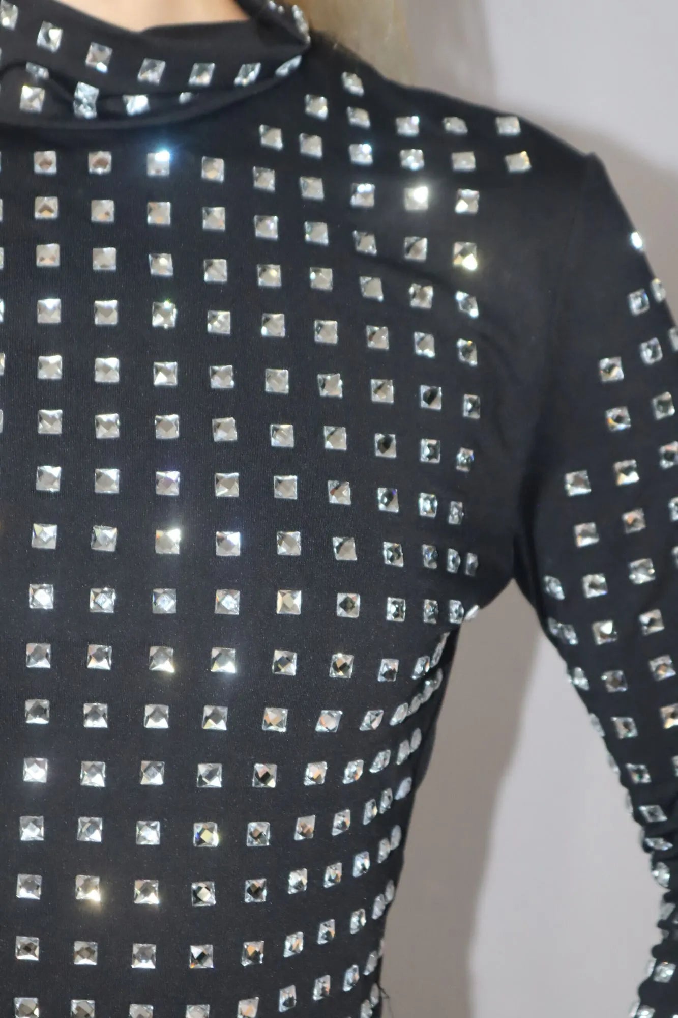 Blusa cropped de mangas compridas e gola alta, com Strass aplicados.